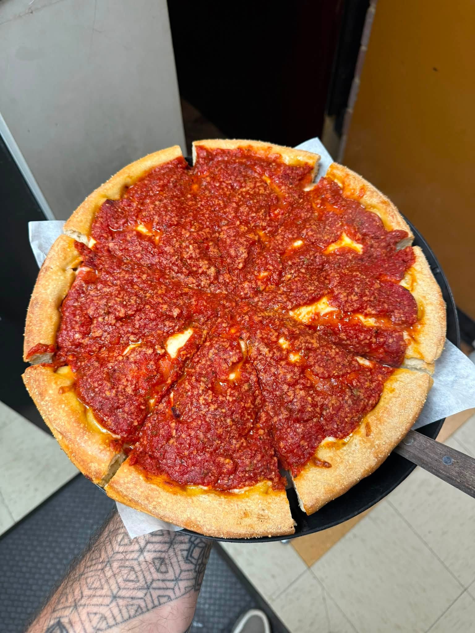 A fresh-cut deep-dish pepperoni pizza, straight out of the oven